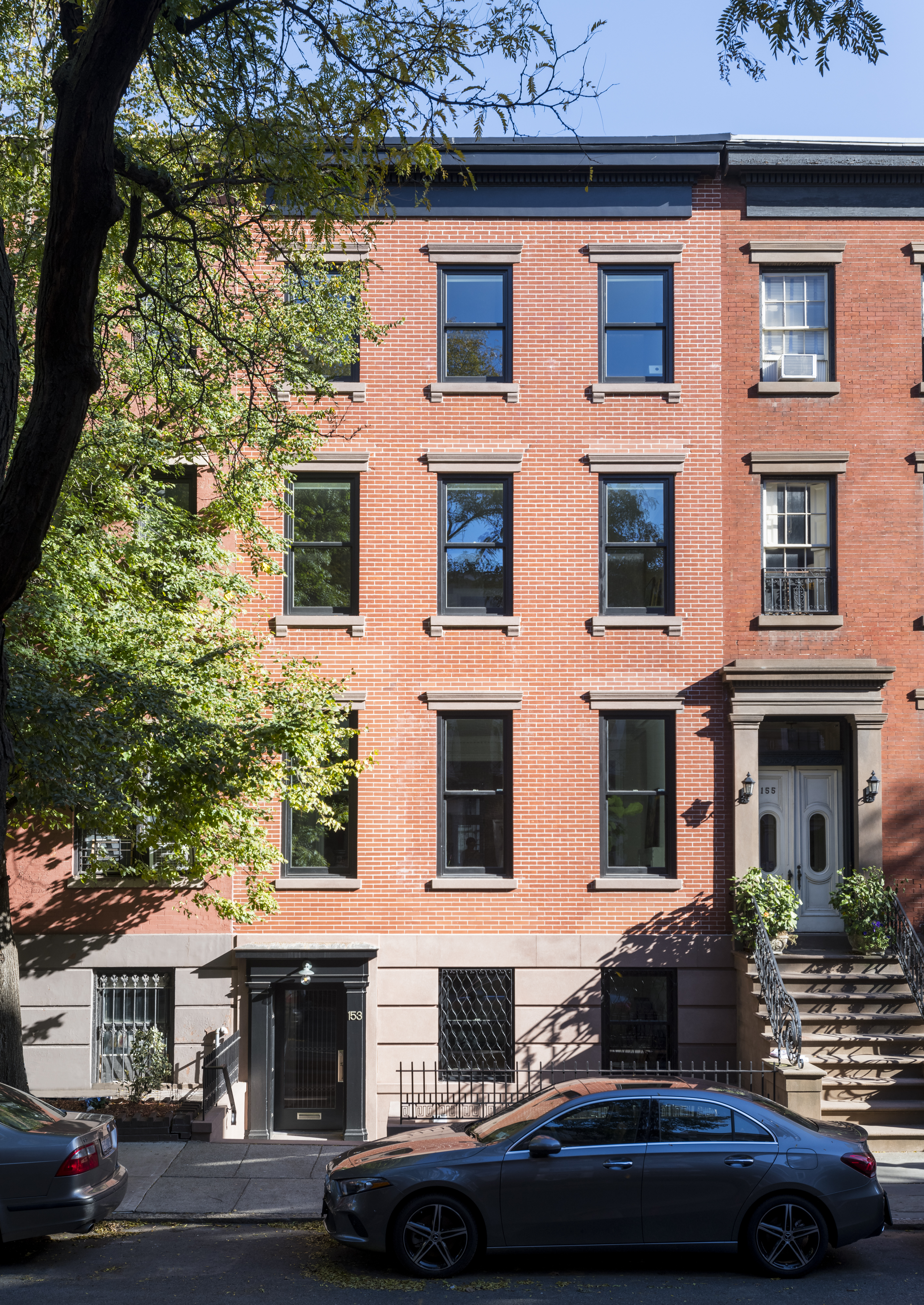 Front façade of a brick townhouse with brownstone lintels and details after our renovation