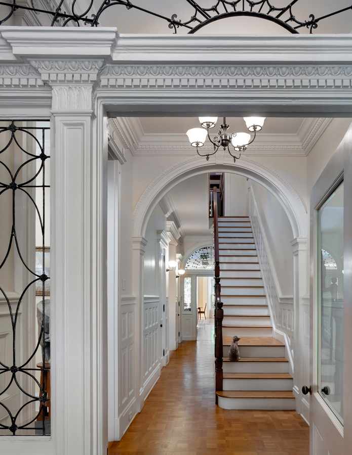 Ironwork, molding, archways, and staircase hallway in a Brooklyn Heights townhouse.
