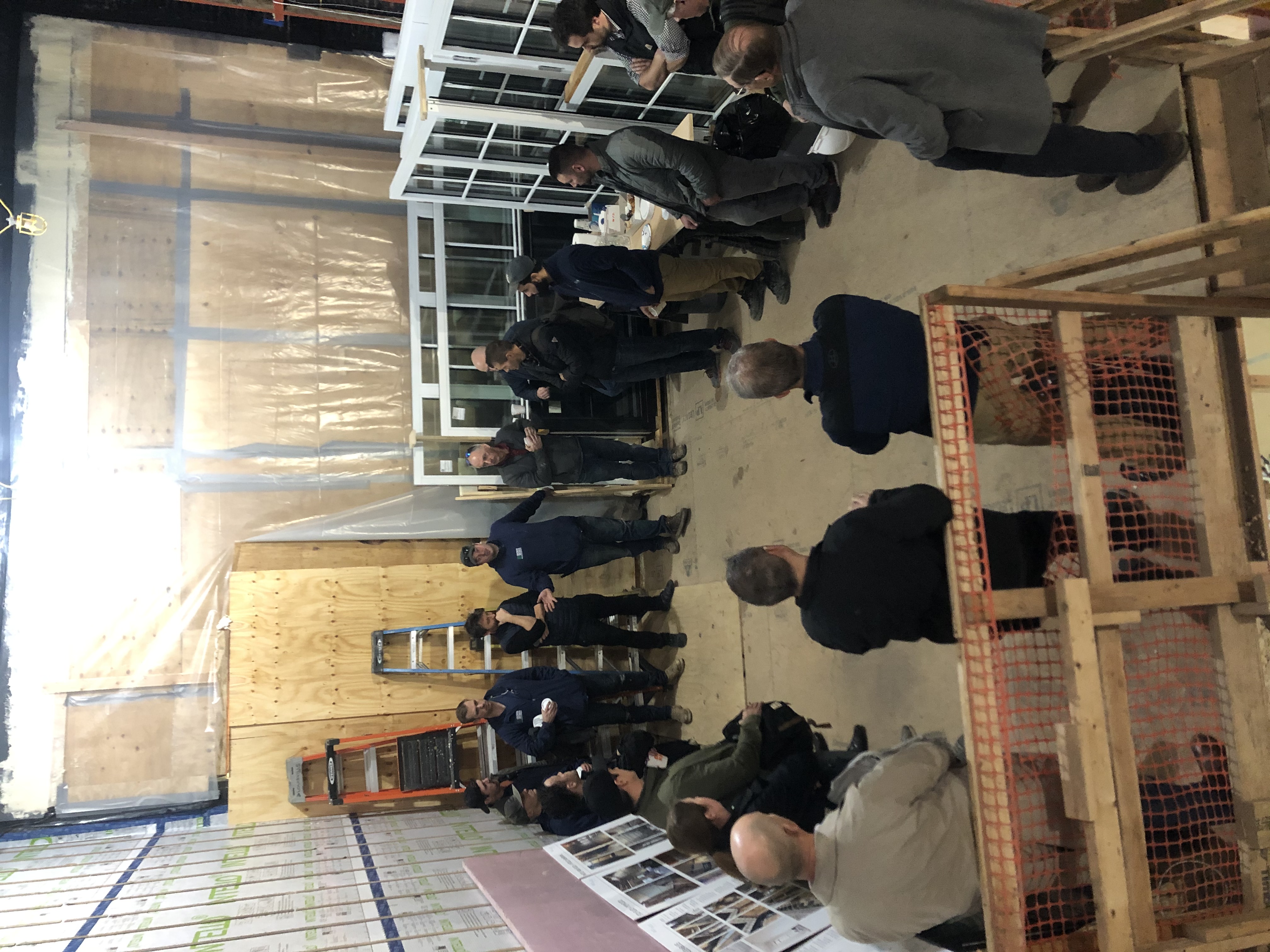 A group of building professionals standing in a circle at a Passive House job site in Brooklyn