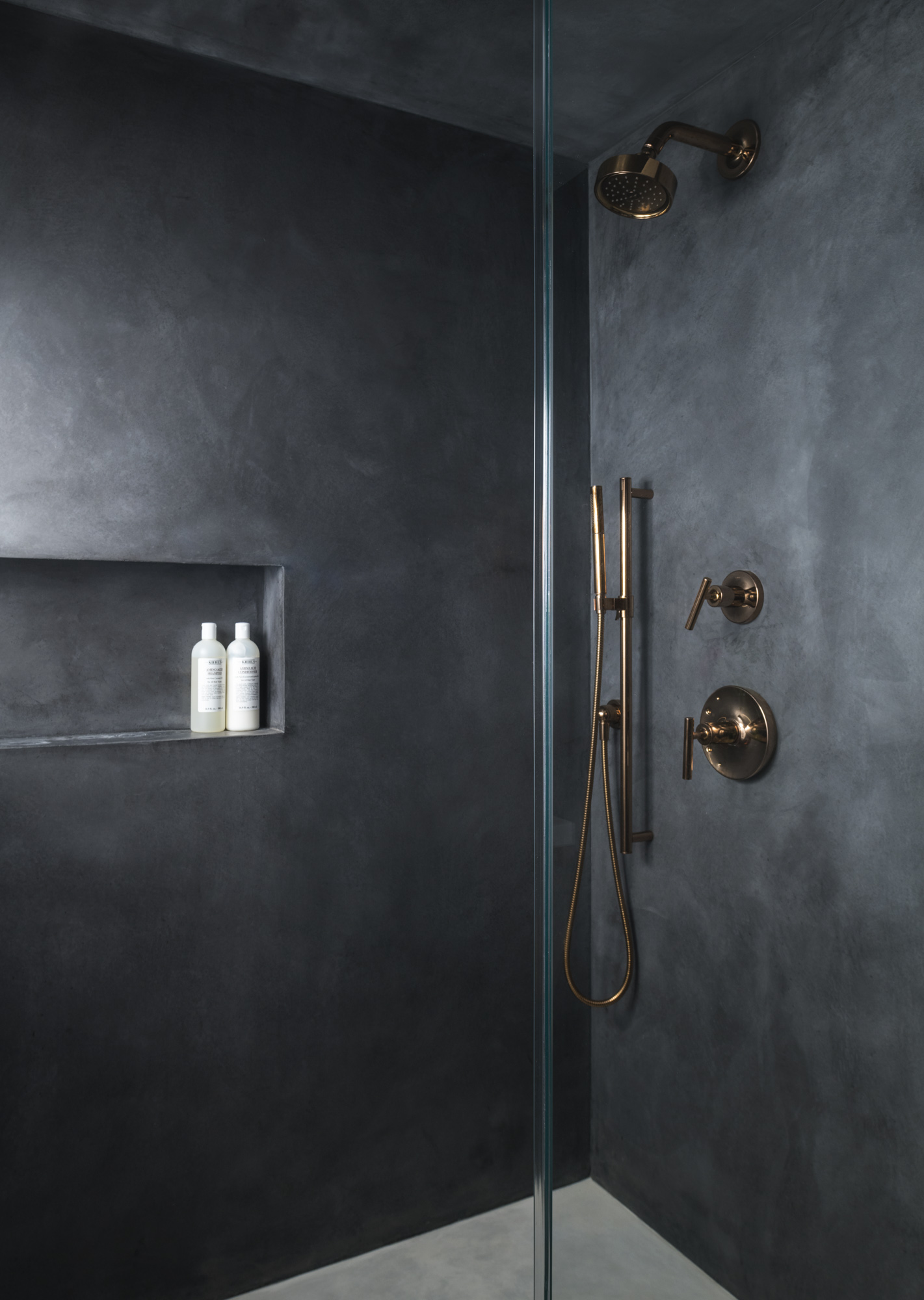 Guest shower with rose gold fixtures and Cementous walls