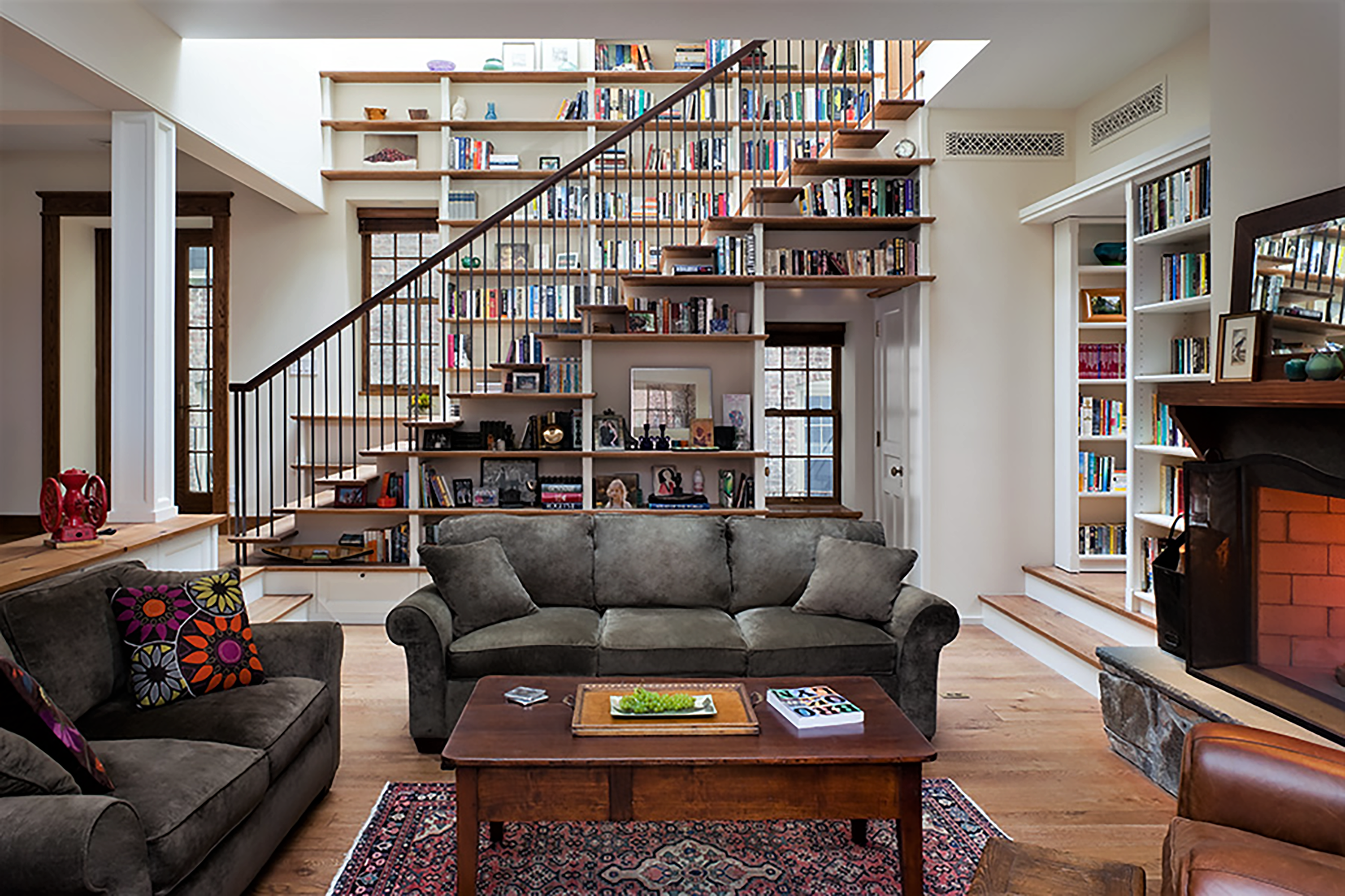 Living room of a Brooklyn Heights carriage house. The staircase leading to the second floor is lined with wood bookshelves on both sides.