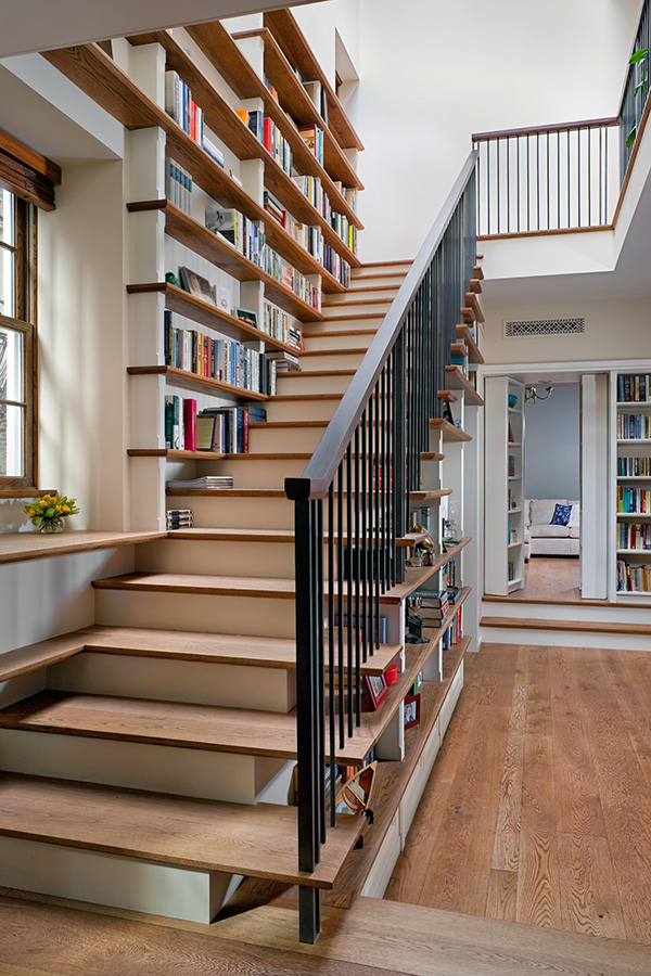 Staircase lined with bookshelves and metal balusters