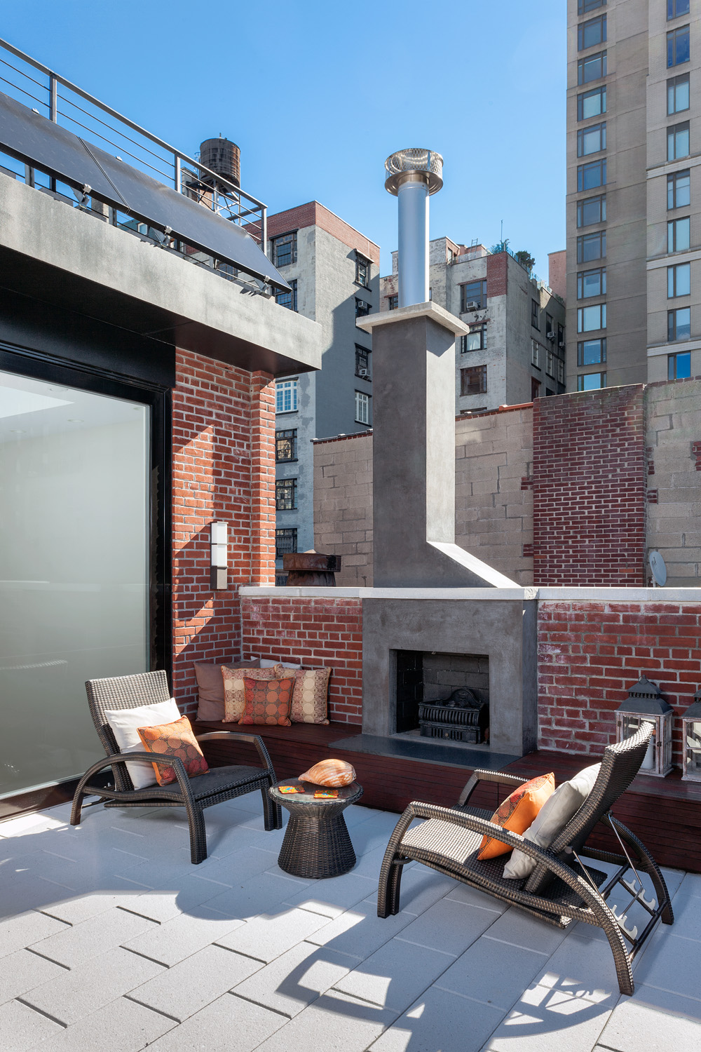 Upper level roof deck with solar panels and a circular couch