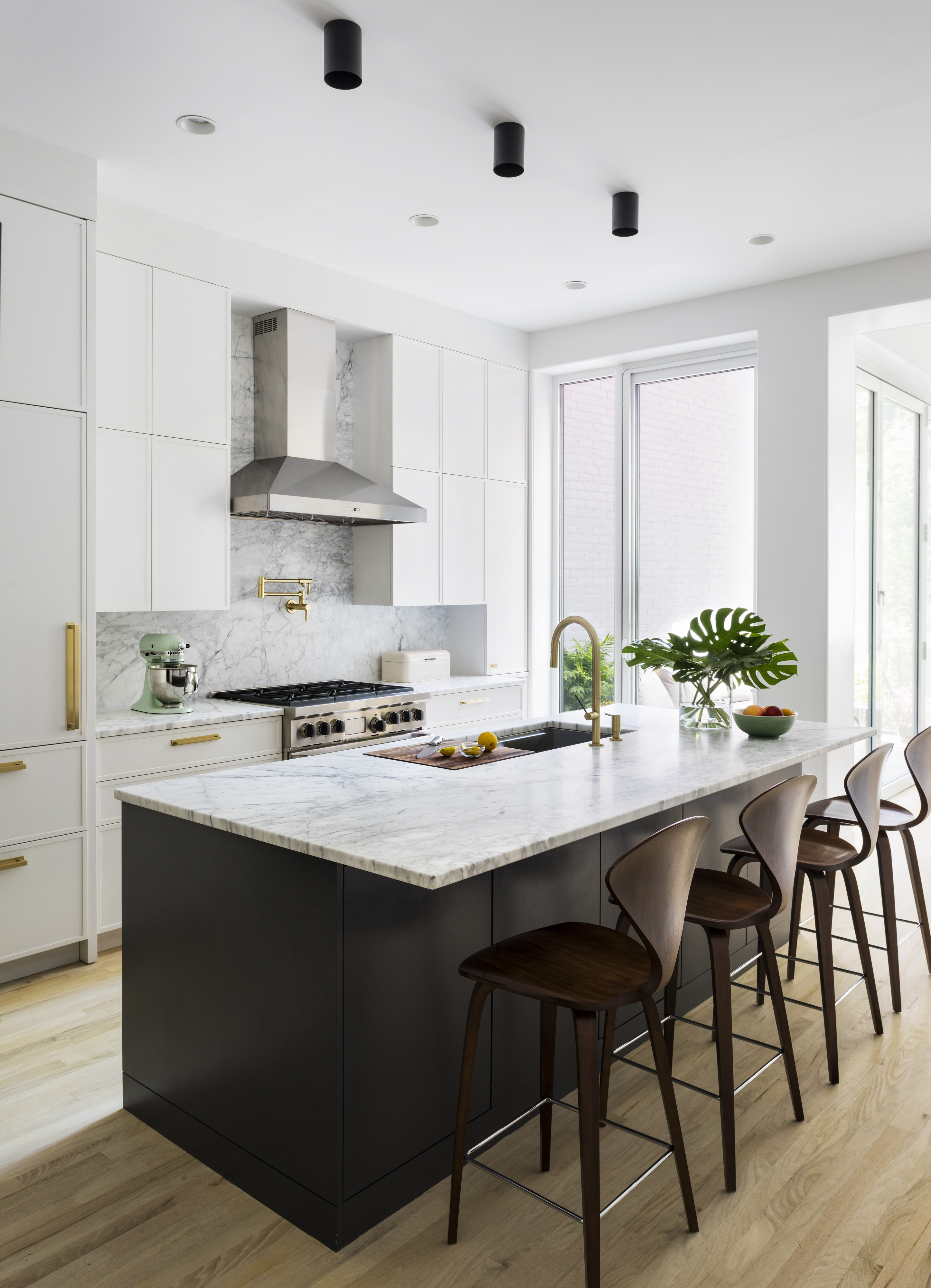 Kitchen in a Prospect Heights home with white millwork, a black island, and white marble countertops.