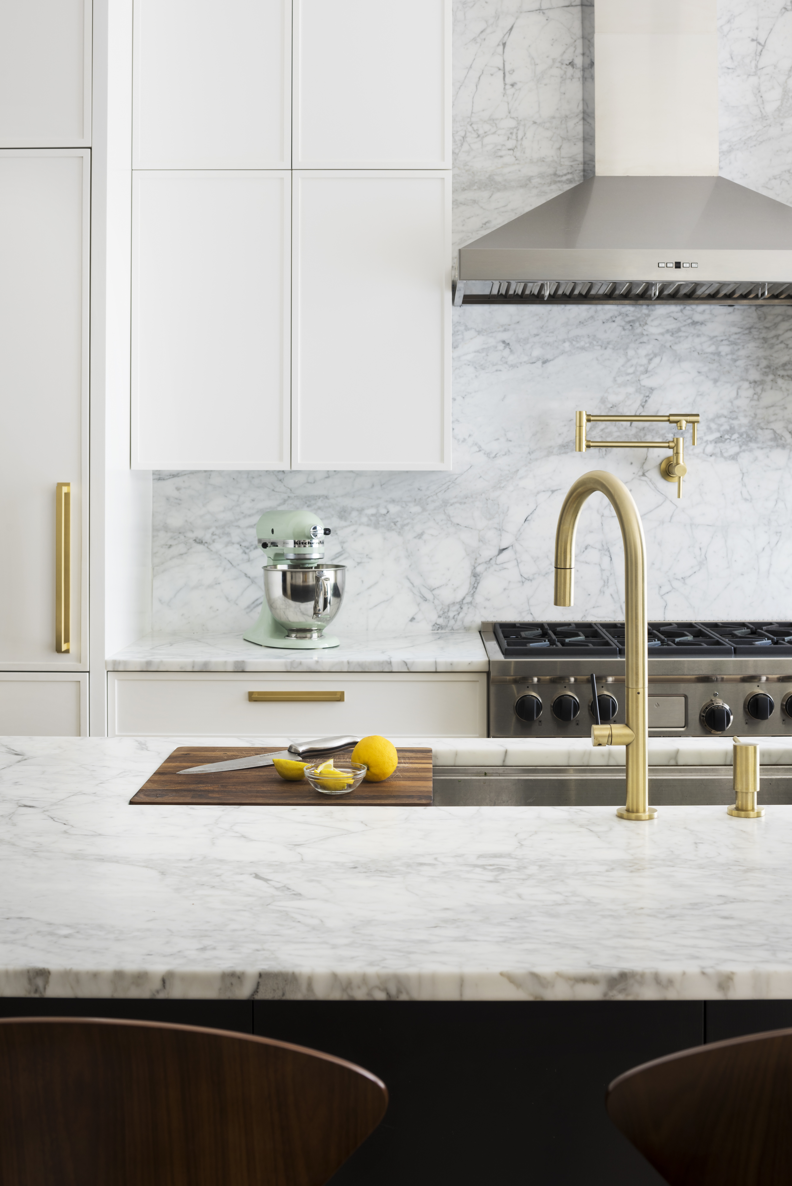 Kitchen in a Prospect Heights home with white millwork, a black island, and white marble countertops.