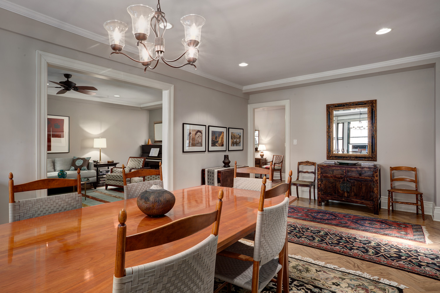 Dining room with oriental rugs over herringbone floors, a new dining table and credenza, and new enlarged opening to the living room